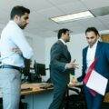 A number of indian office workers standing around stressed