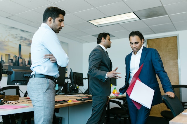 A number of indian office workers standing around stressed