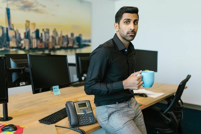 Indian business owner holding a cup looking stressed