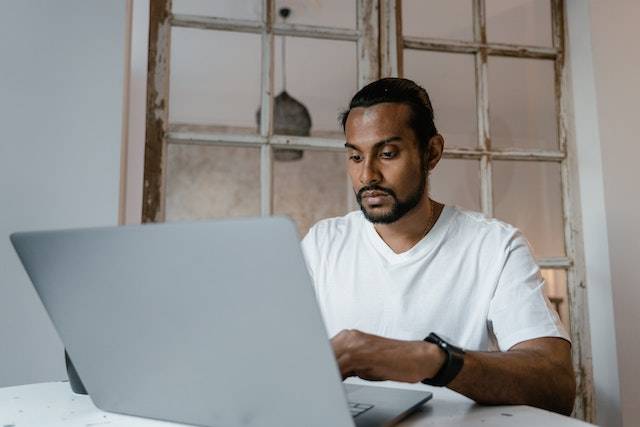Indian entreprenuer at a laptop with a worried look