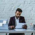 Indian business man looking at a document at his desk