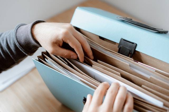 Human sorting through a file folder